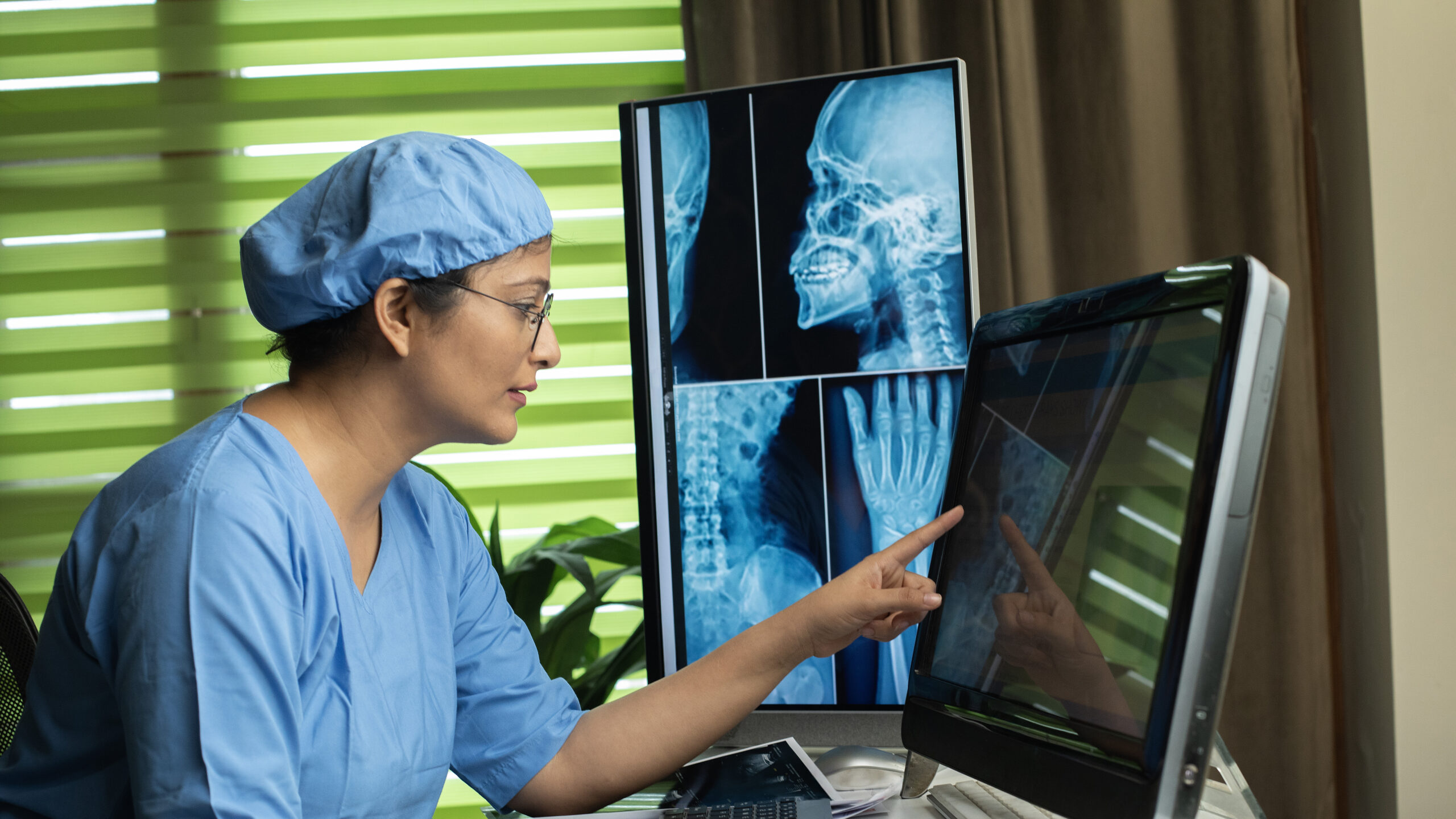 Female nurse analyzing x-ray at desk in hospital