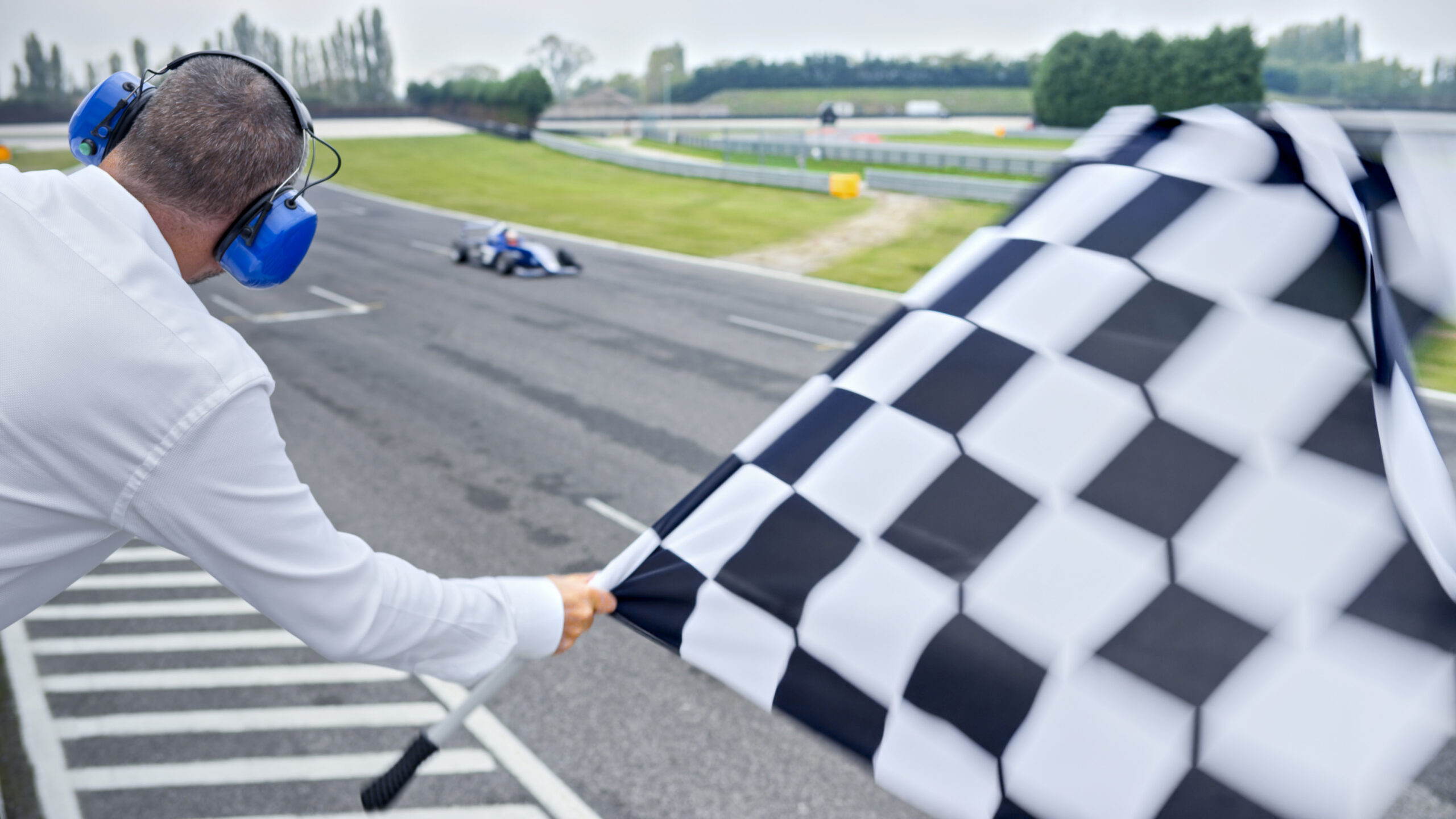 Auto race official waving checkered flag